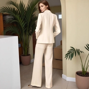 Detail view of the elegant beige slim-fit blazer and wide-leg trousers suit set from behind