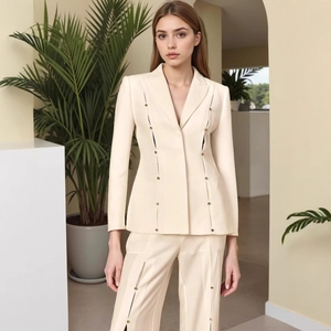 Close-up of golden round buttons and hollow-out design on beige tailored blazer suit