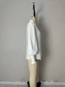 Detail of white shirt showing lantern sleeves with delicate lace trim and elastic cuffs