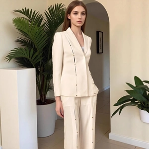 Detail of metal buckle hardware on cream slim-fit blazer and wide-leg trousers set