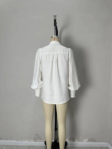White lantern sleeve shirt with delicate lace trim and pleated elastic cuffs back view