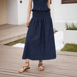 Detail von tiefblauem High-Waist-Denim-Maxirock mit gestufter Textur und Falten-Design