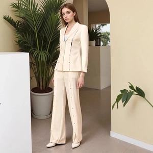 Close-up of cream suit set featuring metallic bar accents and vertical slit design details