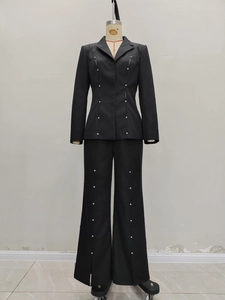 Detail view of silver stud embellishments on slim black blazer and matching trousers