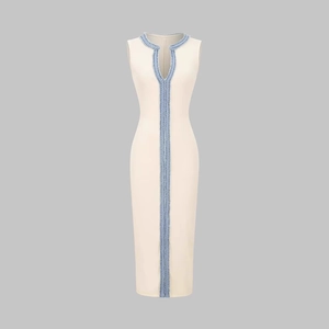 Detailed view of cream knit dress featuring blue braided fringe trim and ribbed texture