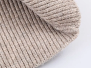 Primo piano del tessuto a maglia a coste beige con morbida trama in lana e alta qualità