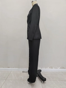 Detailed side view of black slim-fit blazer with metallic decorative buttons on mannequin