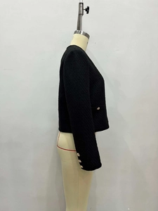 Detailansicht der schwarzen Tweed-Jacke mit Seitentaschen und goldenen Reliefknöpfen