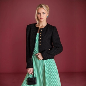 Details der eleganten schwarzen Tweed-Strickjacke mit dekorativen geprägten Goldknöpfen