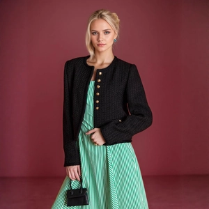 Detailaufnahme der schwarzen Tweed-Strickjacke mit goldenen Knöpfen und Textur-Finish