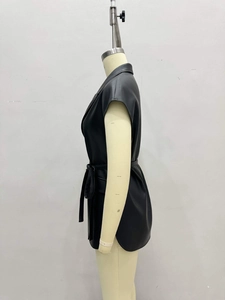Side view of black leather vest with waist tie and notched collar on mannequin