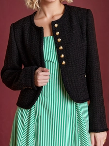 Klassische schwarze Tweedjacke mit Goldknöpfen und Rundhalsausschnitt über grünem Kleid
