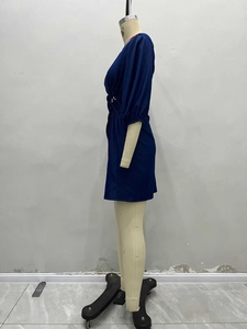 Detailansicht der Puffärmelmanschette und Metallschnalle mit Perlen an einem blauen Kleid