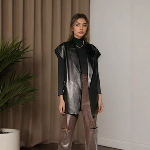 Detail of premium black faux leather sleeveless vest with waist tie and notched lapels