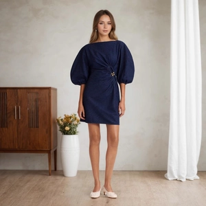Detailansicht der Puffärmel und der goldenen Metallschnalle am marineblauen Kleid