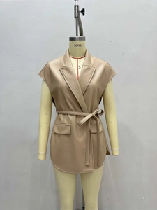 Detail of light tan faux leather vest with notched lapel and adjustable waist tie