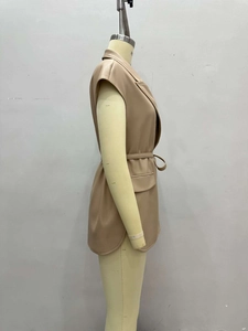 Detail of the chic faux leather vest featuring a notched lapel and adjustable waist belt