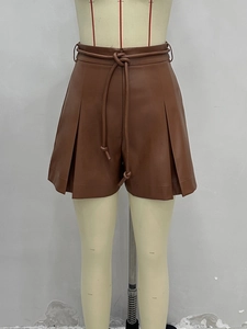 Jupe-short tendance en similicuir marron caramel à taille haute avec plis et ceinture