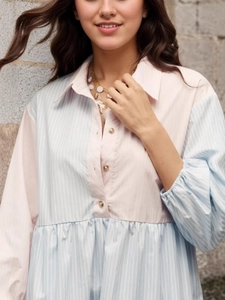 Detail of pink and blue striped shirt dress with pearl buttons and ruffled cuffs