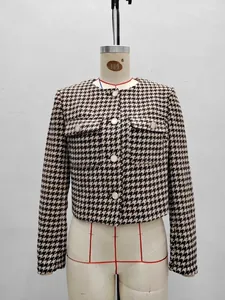 Classic houndstooth tweed jacket with round neck and pearl buttons on a mannequin
