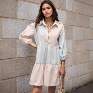 Close-up of pink and blue striped tiered shirt dress with collar and button details