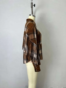 Gros plan détaillé d'une veste en laine à carreaux marron avec de longues franges aux manches