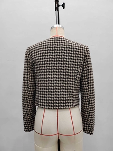 Classic houndstooth tweed jacket with round neck and metal buttons, back view on mannequin