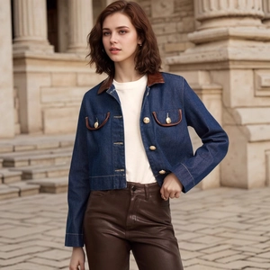 Detail of denim jacket featuring brown leather trim collar and gold buttons