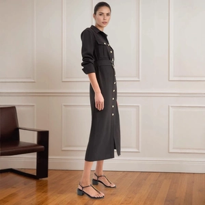 Detail of black shirt dress featuring gold button accents and matching belt with buckle