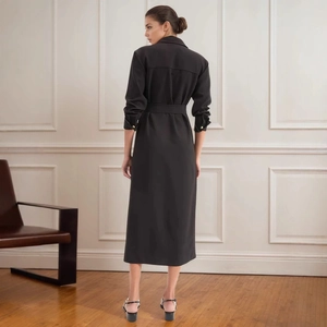 Detail view of the back pleats and cinched waist design of a black midi shirt dress