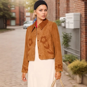 Detail der braunen Wildlederjacke mit elegantem Blumenmuster und klassischem Reverskragen