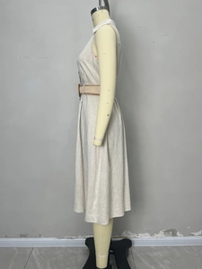 Detail of linen V-neck sleeveless dress featuring a woven belt and natural fabric texture