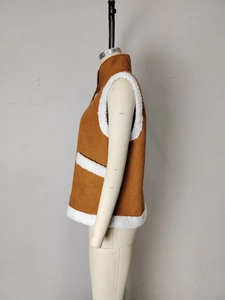 Detailed view of brown corduroy vest with white faux fur lining and side pockets
