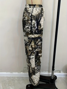 Dettaglio dei pantaloni cargo con stampa mimetica bosco e tasca laterale a patta
