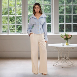 Detail of elegant striped shirt with lapel collar and belted waist paired with white trousers
