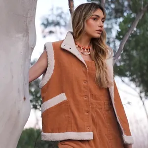 Close-up of brown corduroy vest with white faux fur lining and functional side pockets