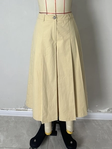 Classic khaki high-waisted pleated A-line skirt with button detail and a long wide silhouette