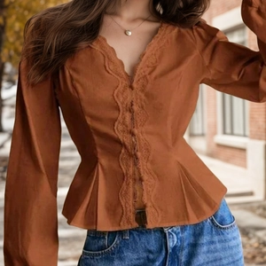 Detail of caramel lace-trim V-neck blouse showing waist-tie and ruffled hem texture
