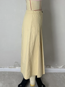 Detail view of khaki pleated long skirt with side pleats and waist button closure
