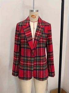 Détail d'un blazer à carreaux rouge et vert avec revers classique et bouton unique
