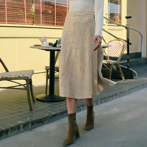 Detail van de A-lijn midi-rok met hoge taille, tweed ruitpatroon en elegante parelknoppen