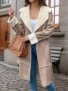 Détail d'un long manteau en faux daim pour femmes avec col et poignets en polaire blanche