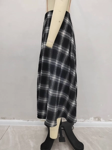 Detail shot of the A-line plaid wool maxi skirt showing high-waisted fit and fabric drape