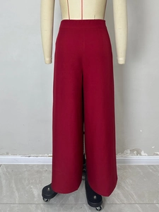 Détail du pantalon large à taille haute plissé taille haute en rouge vin avec un tissu au drapé fluide