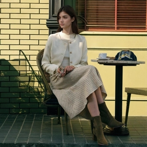 Detail van elegante tweed jas en A-lijn geruite midi-rok voor dames in zakelijke stijl