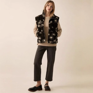 Chic floral print sherpa vest paired with knit sweater and charcoal jeans on model