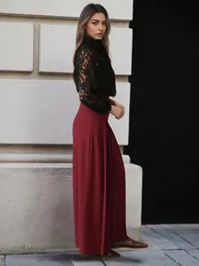 Pantalon large plissé taille haute rouge vin élégant avec un chemisier en dentelle
