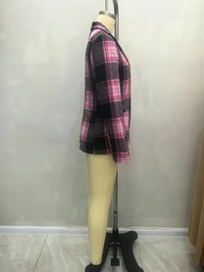 Détail du motif à carreaux rose et noir et de la texture d'un blazer à manches longues