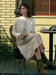 Elegante A-lijn rok met hoge taille gecombineerd met tweed jasje en gebreide top