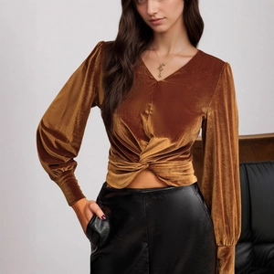 Detail of velvet top featuring twist-knot waist and deep V-neckline in caramel brown